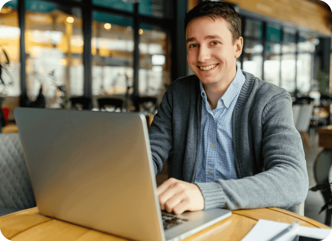 Business owner smiling confidently at a cafe